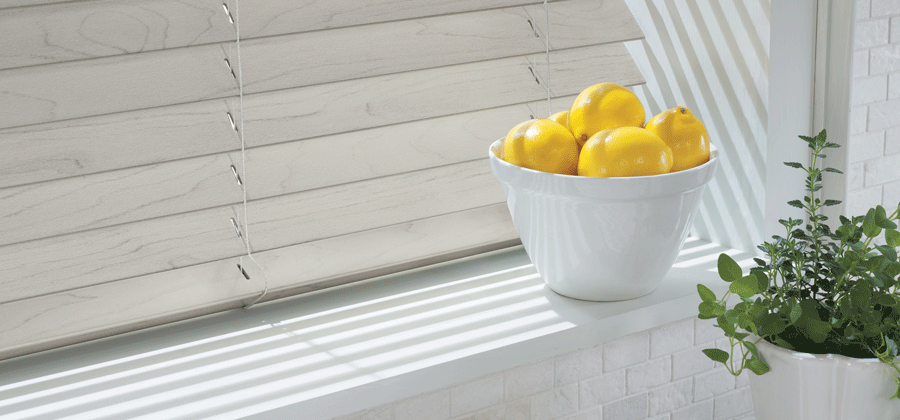 Window sill with faux wood blinds in kitchen.