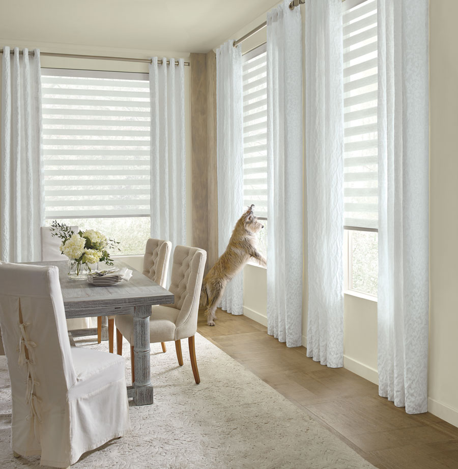 white dining room with white drapery panels and dog on window sill in Burnsville MN