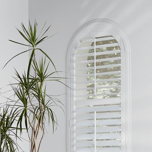 rounded windows with white shutters in home office