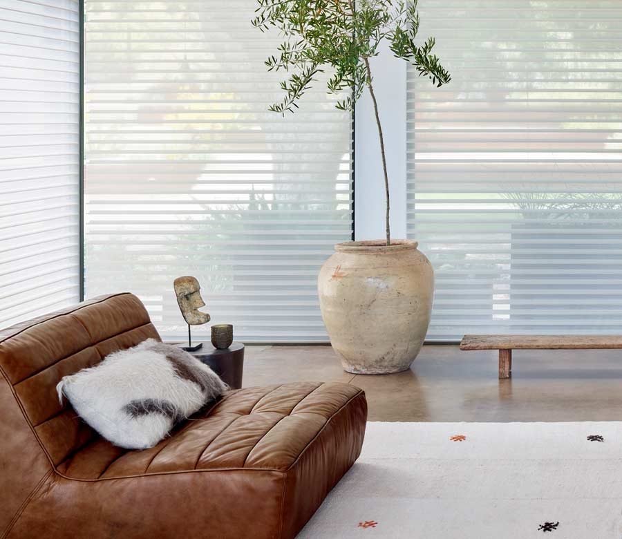 floor to ceiling shades next to leather lounger and large potted tree in Burnsville, MN