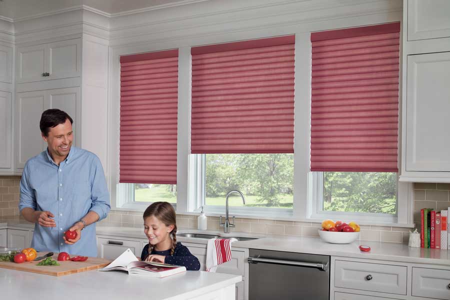 Sonnette™ Cellular Roller Shades in red in a neutral kitchen with a father and daughter cooking.