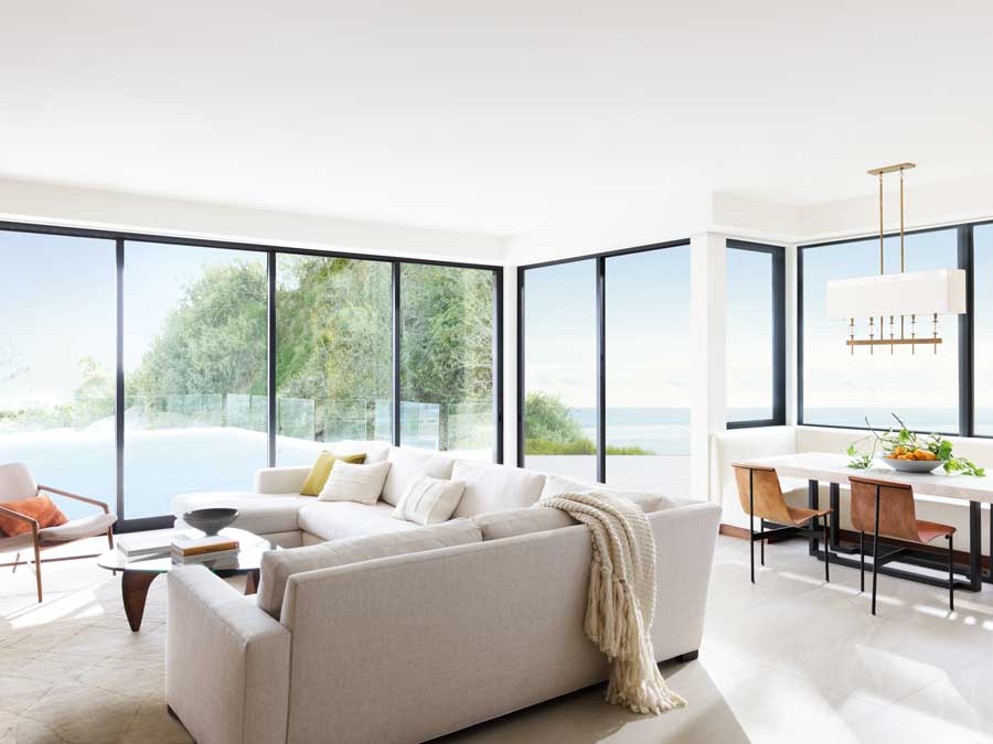 Floor to ceiling black trim windows overlooking a scenic area from the living room