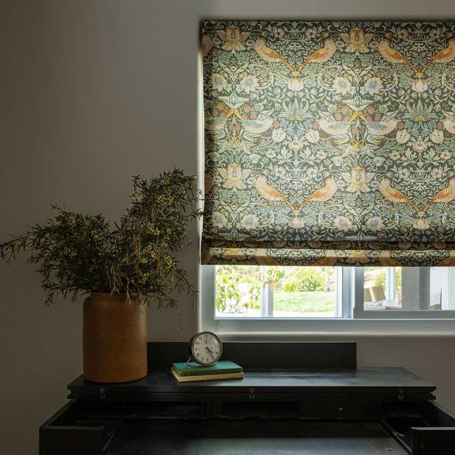 roman shades with birds and plants by desk