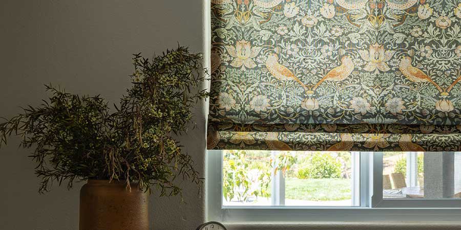 trending fabric patterns that are nature themed with birds and vegetation on window next to plant