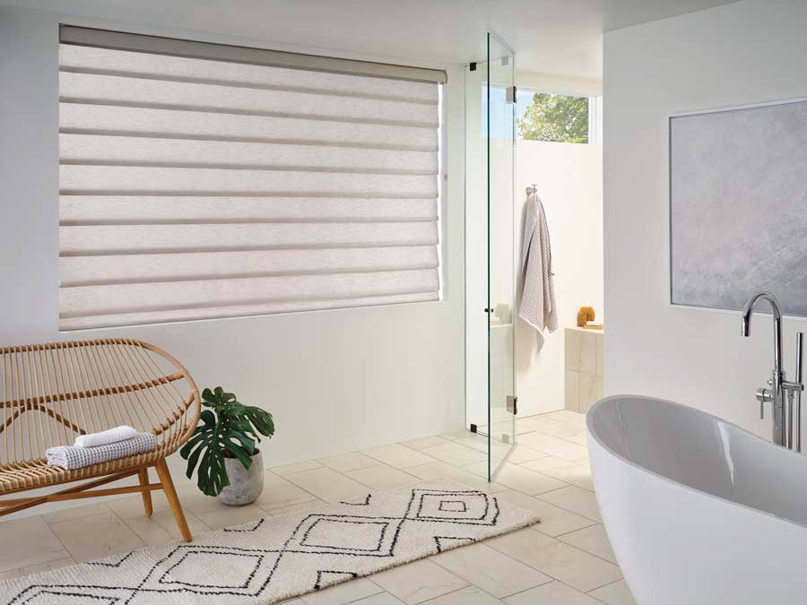 bathroom with white roman window shades with bathtub