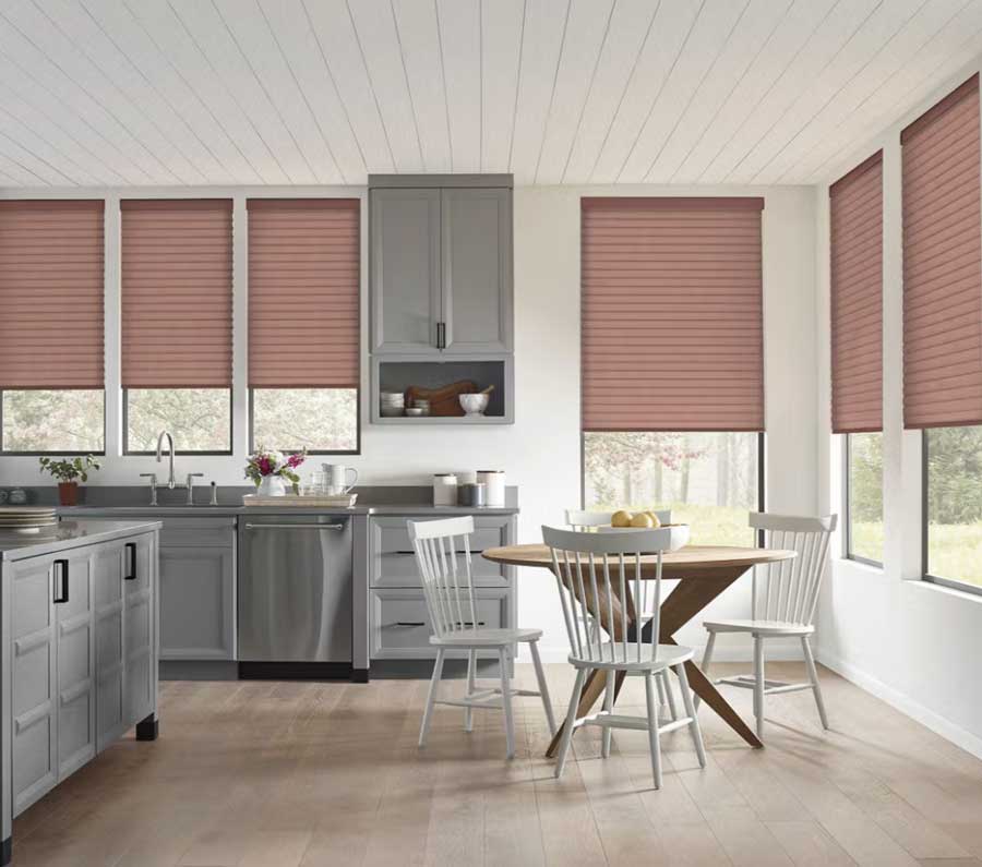 Sonnette shades in a reddish mahogany color covering windows in the shared kitchen dining room space