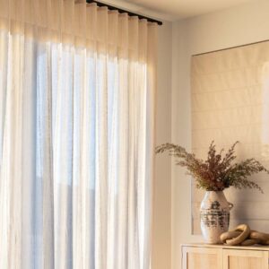 Custom drapery layered with Roman shades in a bright living room